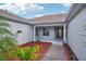 Inviting home entrance featuring a covered porch with decorative plants and a beautifully landscaped yard at 26609 Bull Run, Leesburg, FL 34748
