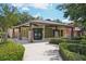 Exterior view of community building with stone columns, lush landscaping, and a welcoming entrance at 26609 Bull Run, Leesburg, FL 34748