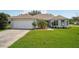 Beautiful single-story home featuring a well-manicured lawn, two-car garage, and inviting curb appeal on a sunny day at 26609 Bull Run, Leesburg, FL 34748