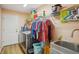 The laundry room features a utility sink, washer, dryer, wire shelving, and a full sized door at 26609 Bull Run, Leesburg, FL 34748