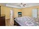 Comfortable main bedroom with wood floors, ceiling fan, and access to en-suite bathroom at 26609 Bull Run, Leesburg, FL 34748