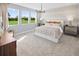Serene bedroom with large windows overlooking a green lawn, complemented by neutral decor at 2681 Ginseng Ivy St, Apopka, FL 32703