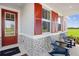 Inviting front porch with red door and shutters, stone accents, and comfortable seating for relaxing outdoors at 2681 Ginseng Ivy St, Apopka, FL 32703