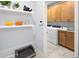 Convenient laundry room with modern appliances, wooden cabinets, floating shelves, and stylish decor at 2681 Ginseng Ivy St, Apopka, FL 32703
