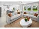 Stylish living room featuring modern sofas, a unique coffee table, and natural light streaming through windows at 2681 Ginseng Ivy St, Apopka, FL 32703