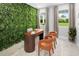 Stylish home office featuring a live plant wall, modern desk, and seating with large windows offering natural light at 2681 Ginseng Ivy St, Apopka, FL 32703