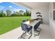 Covered patio with outdoor dining set, offering a perfect spot to enjoy views of the expansive green lawn at 2681 Ginseng Ivy St, Apopka, FL 32703