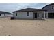 New backyard with patio and a view of the back of the house which has light gray siding and a dark roof at 30112 Misty Pines Rd, Mount Dora, FL 32757