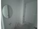 Simple half bath with a round mirror, basic sink, and tiled floors at 30112 Misty Pines Rd, Mount Dora, FL 32757