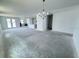 Spacious and bright living room with a chandelier and an open floor plan leading to the kitchen at 30112 Misty Pines Rd, Mount Dora, FL 32757