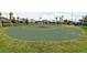 Outdoor basketball court surrounded by green grass and community homes with a water slide visible in the background at 3150 Paradox Cir # 102, Kissimmee, FL 34746