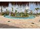 Community lazy river with bridge and tropical landscaping featuring clear water and lounge chairs around the edge at 3150 Paradox Cir # 102, Kissimmee, FL 34746