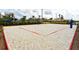 Outdoor sand volleyball court with yellow net and perimeter markers at community park surrounded by greenery at 3150 Paradox Cir # 102, Kissimmee, FL 34746