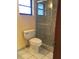 This bathroom showcases a glass-enclosed shower, toilet, and tiled floor, offering a clean and functional space at 3152 Clewiston St, Deltona, FL 32738