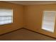 Bedroom featuring two windows for ample natural light and neutral-toned walls and carpet at 3152 Clewiston St, Deltona, FL 32738