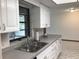 Kitchen features white cabinetry, stainless steel sink and gray countertops, offering a clean and functional cooking space at 3152 Clewiston St, Deltona, FL 32738
