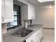 Kitchen features white cabinetry, stainless steel sink and gray countertops, offering a clean and functional cooking space at 3152 Clewiston St, Deltona, FL 32738