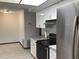 Modern kitchen with stainless steel refrigerator, white cabinets and black stovetop, offering both style and functionality at 3152 Clewiston St, Deltona, FL 32738