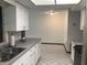 Bright kitchen featuring white cabinetry, gray countertops, and tiled flooring, offering a clean and functional space at 3152 Clewiston St, Deltona, FL 32738