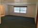 Cozy living room with large window for light, neutral walls, and green carpet at 3152 Clewiston St, Deltona, FL 32738
