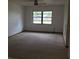 Living space with neutral walls, carpeting, and a large window allowing ample light at 3152 Clewiston St, Deltona, FL 32738