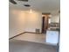 Open living space with neutral walls and flooring leads to a kitchen with white cabinets at 3152 Clewiston St, Deltona, FL 32738