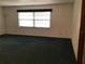 Cozy living room with large window for light, neutral walls, and green carpet at 3152 Clewiston St, Deltona, FL 32738