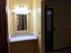 Bathroom vanity area features a decorative mirror and countertop, providing a charming space for grooming and storage at 3152 Clewiston St, Deltona, FL 32738