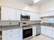 Modern kitchen featuring stainless steel appliances, granite countertops, and sleek white cabinetry for a clean aesthetic at 3208 W Tower Ct, Kissimmee, FL 34741