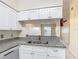 The kitchen has elegant granite counters, and crisp white cabinets that look over into an adjacent living or dining area at 3208 W Tower Ct, Kissimmee, FL 34741
