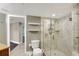 Bathroom boasts neutral tiling, glass shower, toilet and open shelving for storage solutions at 400 E Colonial Dr # 1202, Orlando, FL 32803