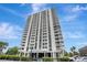 Modern high-rise apartment building with white balconies and sleek design against a clear blue sky at 400 E Colonial Dr # 1202, Orlando, FL 32803