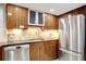Contemporary kitchen featuring wood cabinets, stainless steel appliances, and neutral backsplash at 400 E Colonial Dr # 1202, Orlando, FL 32803