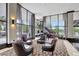 Bright lobby lounge featuring stylish seating surrounding a piano, with floor-to-ceiling windows offering scenic views at 400 E Colonial Dr # 1202, Orlando, FL 32803