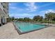 Bright and spacious outdoor pool with lounge chairs surrounded by lush greenery under a blue sky at 400 E Colonial Dr # 1202, Orlando, FL 32803