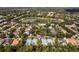 Scenic aerial view showcasing a lake, tennis courts, and homes in a leafy community at 405 E Freesia Ct, Deland, FL 32724