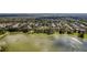 Beautiful aerial view of homes in a lakeside community surrounded by lush greenery and mature trees at 405 E Freesia Ct, Deland, FL 32724
