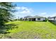 Expansive backyard features mature landscaping, a fence, and an enclosed porch at 405 E Freesia Ct, Deland, FL 32724
