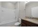 Bathroom boasts granite vanity top and a shower-tub combo with tiled surround at 405 E Freesia Ct, Deland, FL 32724