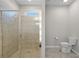 Bathroom featuring tiled shower with glass doors, a toilet and tile floors at 405 E Freesia Ct, Deland, FL 32724