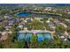 Aerial view featuring the community's tennis courts, pool, and a serene lake, highlighting the recreational amenities at 405 E Freesia Ct, Deland, FL 32724