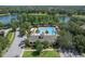 Aerial view of the community pool area, with a pool, clubhouse, and palm trees at 405 E Freesia Ct, Deland, FL 32724