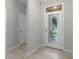 Bright foyer featuring tile flooring, a decorative glass front door, and white trim, creating an inviting entrance at 405 E Freesia Ct, Deland, FL 32724