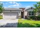A single story home with a manicured lawn, stone accents, and a two car garage at 405 E Freesia Ct, Deland, FL 32724