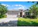 Charming single-story home with a well-maintained lawn and attached two-car garage at 405 E Freesia Ct, Deland, FL 32724