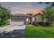 Charming single-story home with a well-manicured lawn and attached two-car garage, set against a colorful sunset sky at 405 E Freesia Ct, Deland, FL 32724