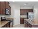 Modern kitchen equipped with stainless steel appliances, granite countertops, island, and gas range at 405 E Freesia Ct, Deland, FL 32724
