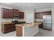 Stylish kitchen featuring granite countertops, stainless steel appliances, ample cabinets, and central island at 405 E Freesia Ct, Deland, FL 32724