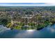 Aerial view featuring the lake with a pool and clubhouse framed by mature trees at 405 E Freesia Ct, Deland, FL 32724