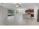 Open-concept living room features tile flooring, ceiling fan, and sliding glass door leading to the outside at 405 E Freesia Ct, Deland, FL 32724